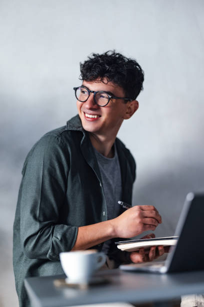 istock Smiling Person Writing in Notebook at a Cozy Workspace 2194195540