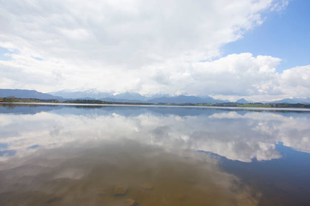 View of Lake Chiemsee, Bavaria's largest lake, and the Chiemgau Alps with a cloudy sky