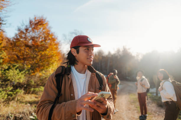 istock Young man using maps on mobile phone while on a hiking trip with friends 2194196876
