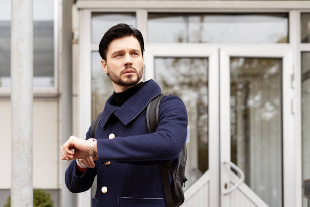 istock Handsome bearded man checking time on city street 2194198987