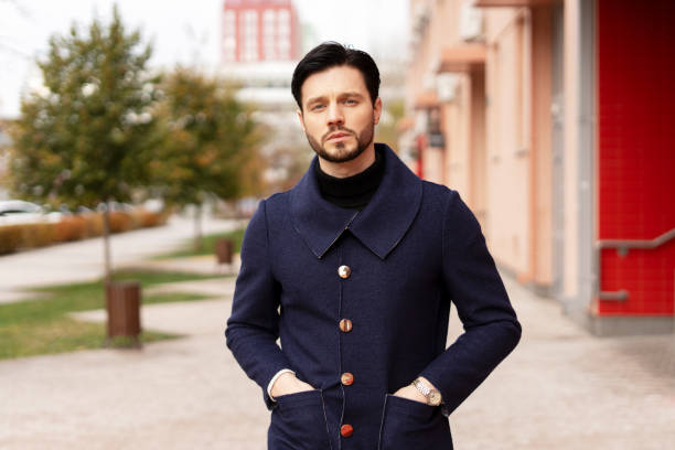 istock Confident young bearded man holding hands in pockets looking at camera in the city 2194199032