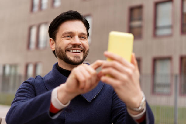 istock Confident young businessman using cell phone in the city, typing message 2194199048