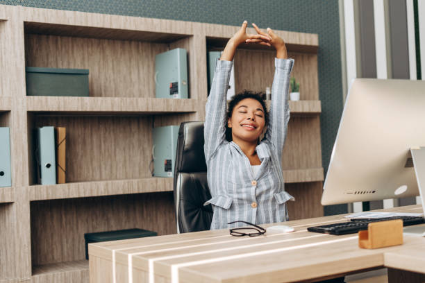 istock Businesswoman stretching at office desk after work computer session 2194199234