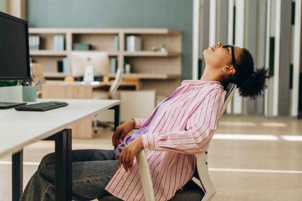 Office worker relaxing on chair with eyes closed after work
