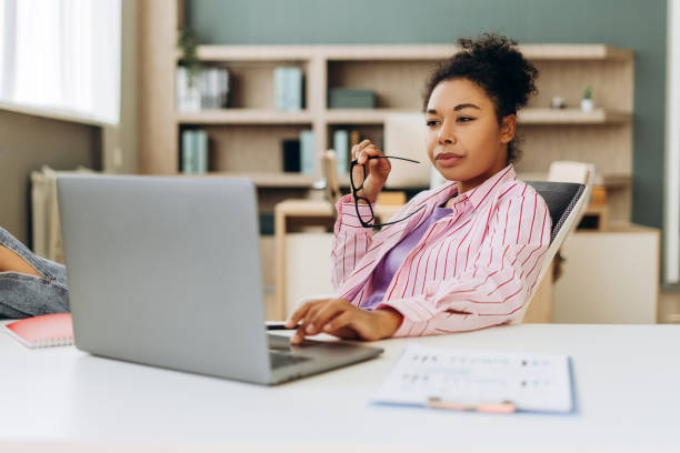 istock African American woman, manager working from home office using laptop and thinking 2194199835