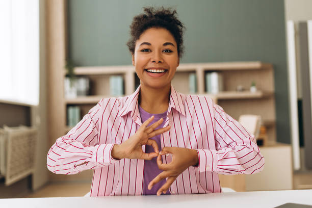 istock Smiling woman using sign language at home office desk 2194199856