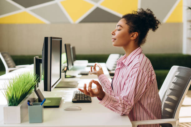 istock Office worker meditating at her desk for stress relief 2194199867