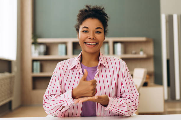 istock Smiling woman using sign language at home office desk 2194199870