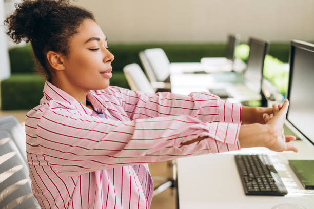 istock Office worker stretching arms at desk in modern office 2194199873