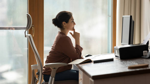 istock Side view thoughtful Indian businesswoman looking at computer screen 2194204998