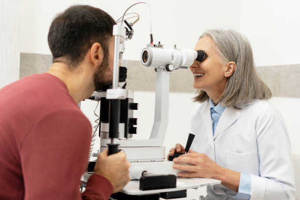 istock Senior ophthalmologist performing eye exam on male patient using slit lamp biomicroscope 2194207515