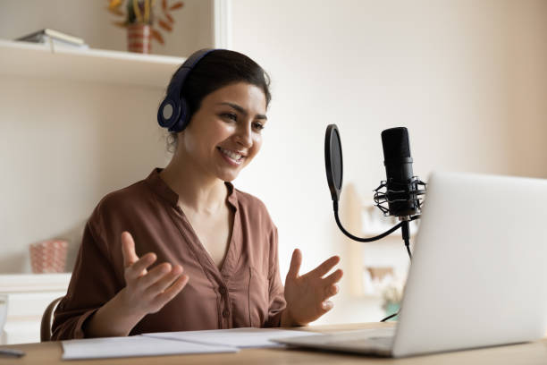 istock Smiling Indian woman in wireless headphones talking, using professional microphone 2194208089