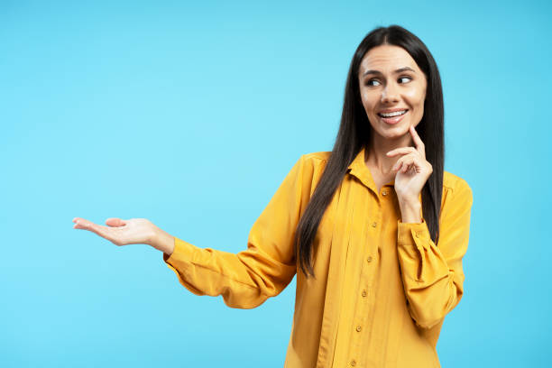istock Attractive Hispanic middle aged woman showing and presenting with open hand palm on blue background 2194209547