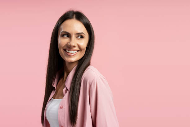 istock Smiling woman looking away on pink background, copy space studio portrait 2194209803