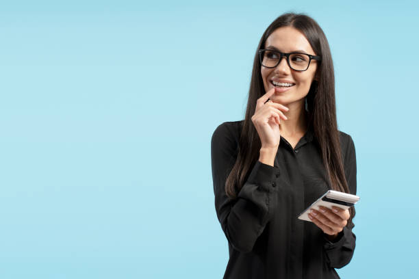istock Businesswoman holding smartphone and thinking on blue background copy space 2194209903