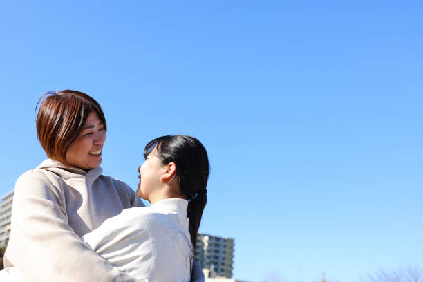 Japanese families enjoying spending quality time together naturally in casual, relaxing, non-sporting situations outside.