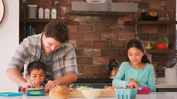 istock Father And Children Making Sandwiches For School Packed Lunch In Kitchen 2194212845