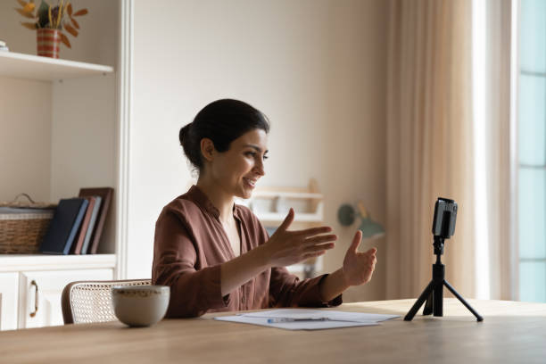 istock Smiling Indian young woman using smartphone on tripod, recording video 2194213886