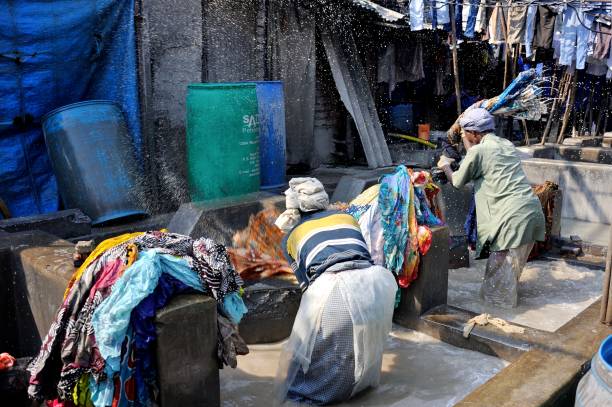 laundrymen are working in Dhobi Ghat Laundry District, a well know open air laundromat in downtown, Mumbai, Maharashtra State, India.