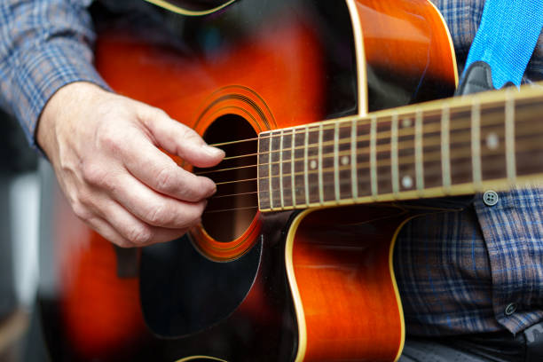 istock A man plays an acoustic guitar in close-up. 2194218788