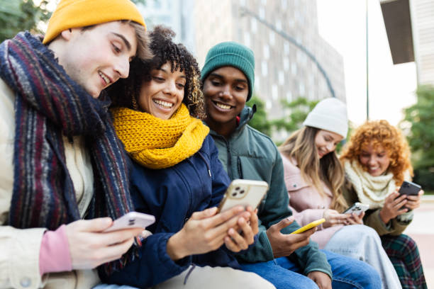 istock Group of young diverse people using smart phones sitting on bench in winter 2194220739