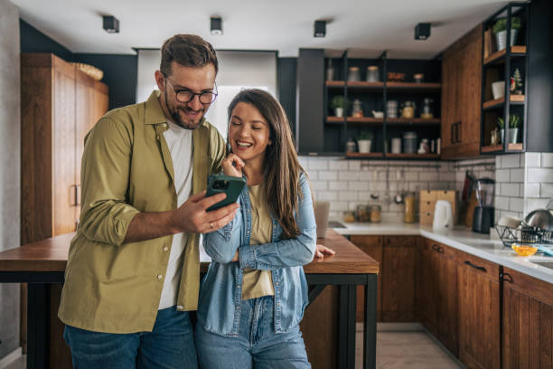 istock Couple looking at a phone in the kitchen 2194222141