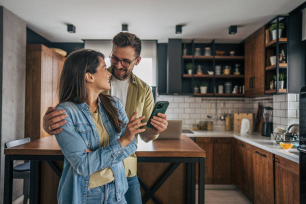 istock Couple looking at a phone in the kitchen 2194222182