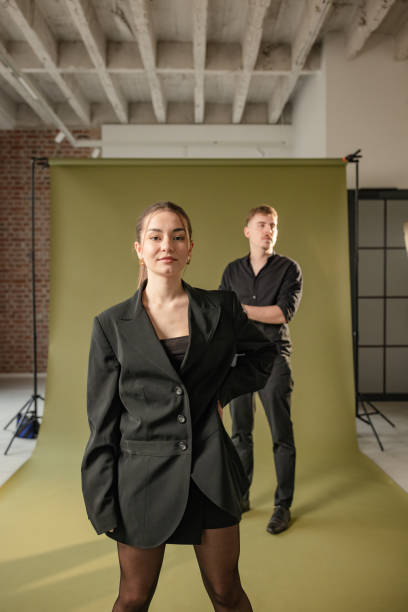 istock Confident woman poses with man in blurred background. 2194222230