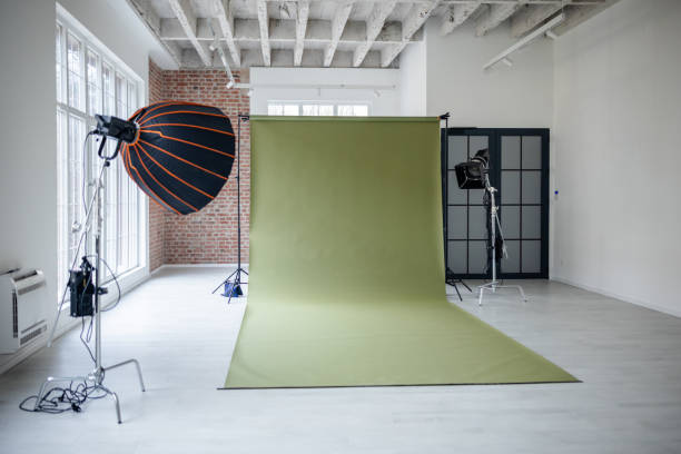 empty photo studio with a green backdrop setup - fotoğraf seansı stok fotoğraflar ve resimler