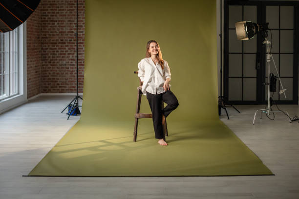 istock Female model poses confidently with hands on the chair. 2194223118