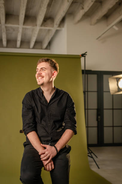 istock Happy man laughing in photo studio with green background. 2194223806
