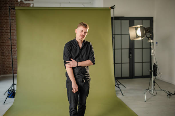 istock Man in black shirt poses in studio with green backdrop. 2194224780