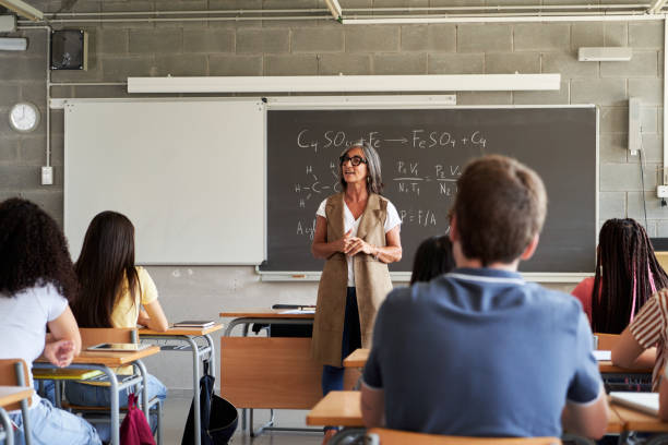 istock Mature female teacher explaining chemistry formulas to high school students. 2194224829