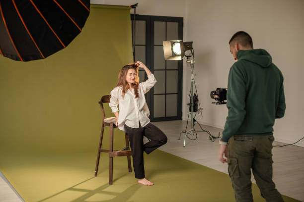 istock Man photographs woman in well-lit creative studio. 2194224886