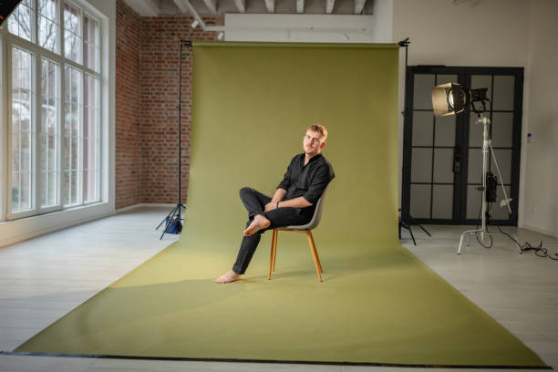 istock Man rests on chair in sunlight-filled green studio 2194224961