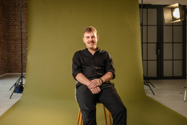 istock Man sitting on chair in stylish photo studio setup 2194225180