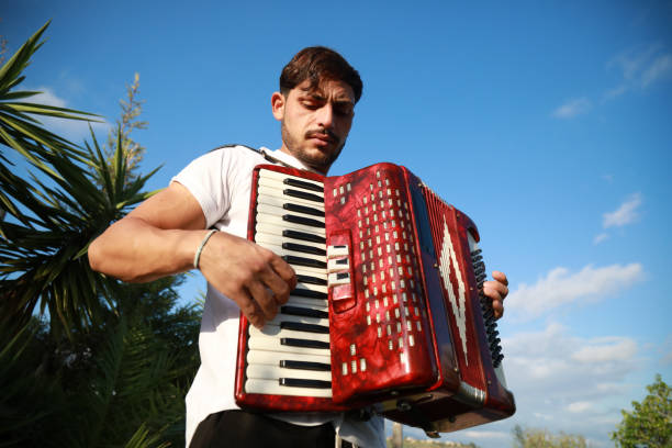 Italian street musician playing the accordion in Napoli streets. Naples, Italy - September 13, 2022