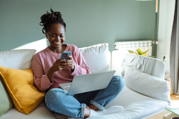 istock Woman browsing her smartphone while sitting on a modern sofa at home 2194227547
