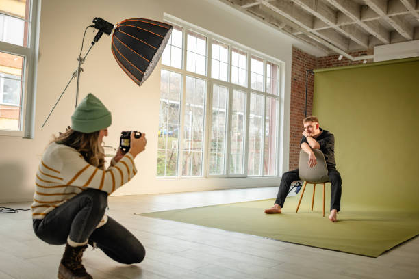 istock Photographer captures seated man in creative studio 2194227596