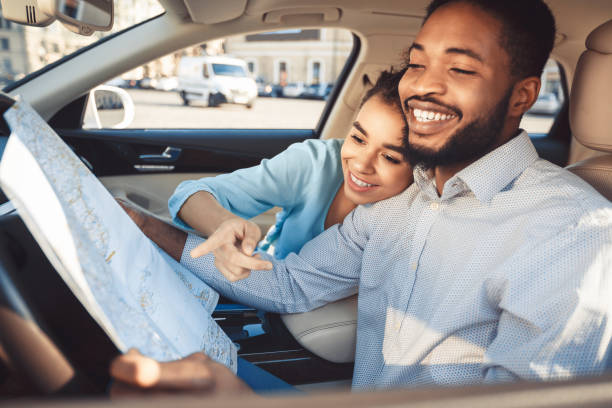 istock Couple Enjoying a Playful Moment While Navigating With a Map Inside a Car 2194228971