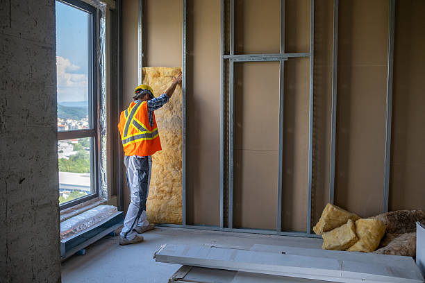 Drywall worker puts a mineral wool on the wall on a construction site.