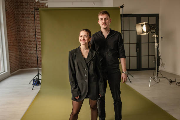 istock Stylish couple elegantly posed against green backdrop. 2194230470