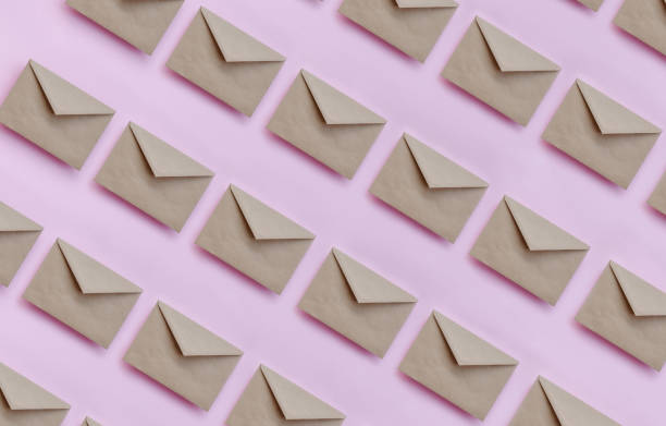 Kraft brown paper envelopes on pink background