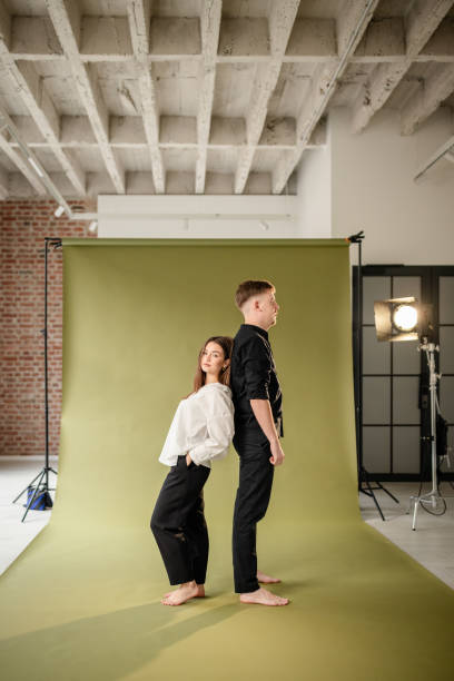 istock Two people standing back to back in a photo studio 2194231188