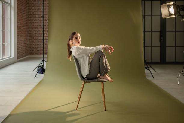 istock Woman balancing gracefully on chair in neutral space 2194231321