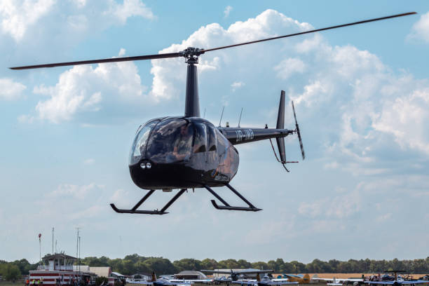 Kharkiv, Ukraine - August 29, 2021: Helicopter Robinson R44 Raven II takeoff on KharkivAviaFest airshow in scenic clouds