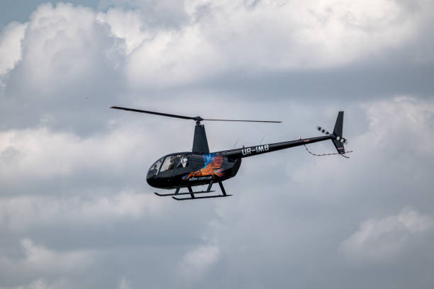 Kharkiv, Ukraine - August 29, 2021: Helicopter Robinson R44 Raven II in cloudy sky on KharkivAviaFest airshow