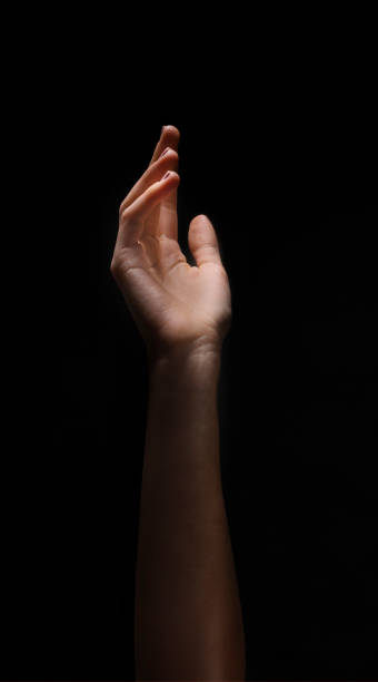 istock Hand Reaching Towards Light Against a Dark Background During a Creative Art Project 2194236250