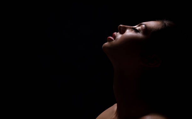 istock Woman in Contemplative Pose Against Dark Background With Soft Light Highlighting Features 2194236296