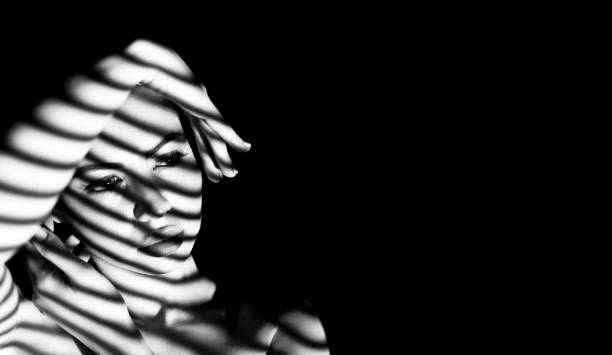Dramatic Play of Light and Shadow on a Woman's Face in Striking Black and White